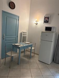 une petite cuisine avec une table bleue et un réfrigérateur dans l'établissement Studio tout confort, à La Crau