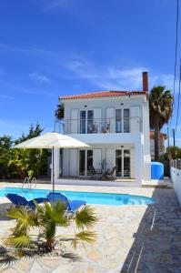 een wit huis met een parasol en een zwembad bij Villa Arcadia in Zakynthos