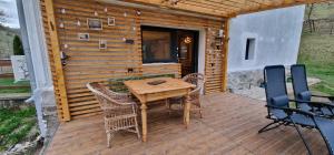 eine Holzterrasse mit einem Holztisch und Stühlen in der Unterkunft LaShura in Buceş