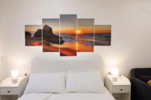 a sunset over the ocean canvas wall art at La Vega Comfort Stay in Cagliari