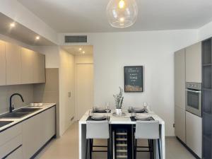a kitchen with white cabinets and a kitchen island with stools at La Perla del Mare in Anzio