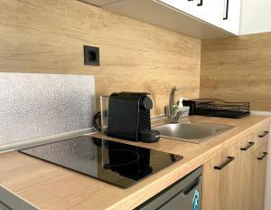 a kitchen counter with a sink and a microwave at Thalassa Garden Studios in Pefkochori