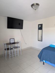 a bedroom with a table and chairs and a tv at 2 minutos de Mall Las Cascadas Apartamento Completo in Tegucigalpa