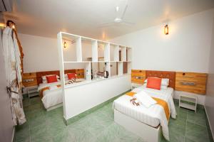 um quarto com duas camas e um espelho em Velana Vibes at Mathiveri em Mathiveri
