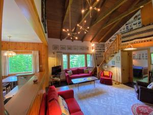 a living room with a red couch and a table at 23SR Traditional Austrian Chalet at the base of Cannon Ski Area in Franconia Notch in Franconia