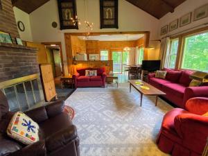 a living room with red furniture and a fireplace at 23SR Traditional Austrian Chalet at the base of Cannon Ski Area in Franconia Notch in Franconia