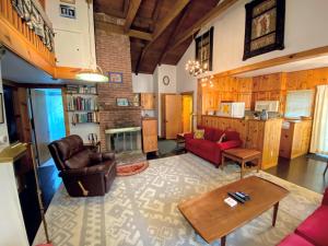 a living room with a red couch and a fireplace at 23SR Traditional Austrian Chalet at the base of Cannon Ski Area in Franconia Notch in Franconia +40 photos