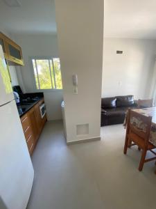 ゴヴェルナドール・セウソ・ラーモスにあるApartamento Bosque das Oliveiras - Palmasのソファとテーブルのあるキッチンとリビングルーム
