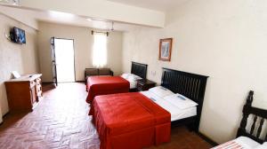 a hotel room with two beds and a couch at Hotel Guivá San Pablo in Hacienda Blanca