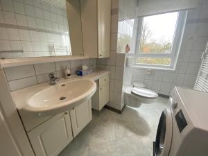 フレンスブルクにあるFerienwohnung Parkgartenの洗面台とトイレを備えた白いバスルーム +16枚の写真
