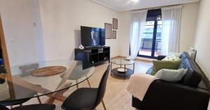 a living room with a glass table and chairs at VT Dos Soles in Lardero