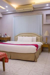 a bedroom with a large bed with a white bedspread at Elegant Enchanted in Dhaka