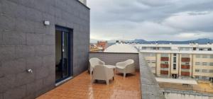 a balcony with chairs and a table on a building at VT Dos Soles in Lardero