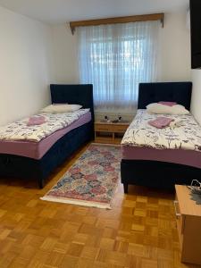 a bedroom with two beds and a window at Sobe Lara in Gradačac