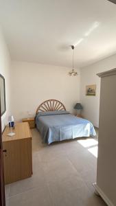 a bedroom with a bed and a nightstand and a bed sidx sidx sidx sidx at Villa Ingrosso in Leporano Marina
