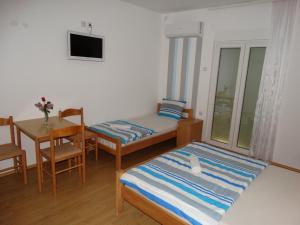a small room with a bed and a table and a desk at Vila Jenic in Soko Banja