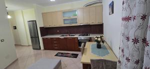 ヴロラにあるApartment me qera Lungomare Vlore Dejvid by the seaのキッチン(テーブル、シンク、冷蔵庫付)