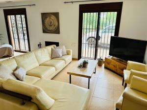 ein Wohnzimmer mit Couch und Flachbildfernseher in der Unterkunft Villa Milan in Alhaurín el Grande