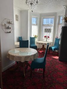 a dining room with a table and blue chairs at Holland House in Great Yarmouth