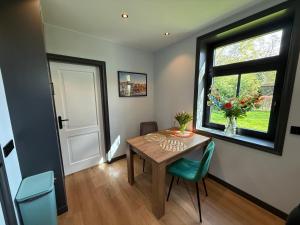 a dining room with a table and a window at Urk-Stay in Tollebeek