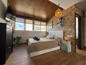 a bedroom with a bed and a stone wall at Chalet en Mar Menor Urb las Góndolas in La Manga del Mar Menor