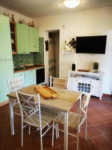 a kitchen with a table and chairs and a tv at Live Sea and Nature in Costa Paradiso