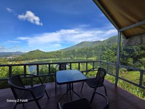 a table and chairs on a balcony with a view at Seroja Hills Glamping Wonosobo in Kejajar