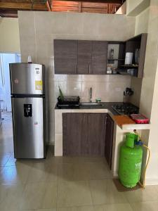 a kitchen with a refrigerator and a sink at Camalaga in Nuquí