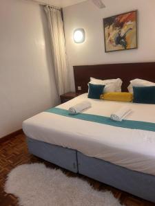 a bedroom with a large bed with blue and white sheets at The Zola lantana Westlands in Nairobi