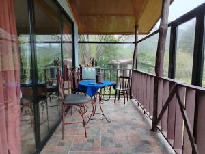 a screened in porch with a blue table and chairs at Suite y Loft Casa Toría in San Isidro