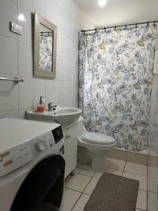 un bagno con lavandino, WC e tenda da doccia di Cabaña el Maiten a Guayacán