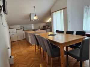 a kitchen and dining room with a wooden table and chairs at Apartments Šeherzada in Pula