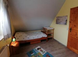 a small bedroom with a small bed and a window at Dat Osterhuus in Neßmersiel