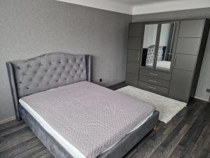 a bedroom with a bed and a dresser and a mirror at Cozy apartment in Ventspils