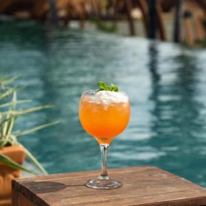 a drink sitting on a table next to a pool at Apenunga Eco Hotel in Jericoacoara