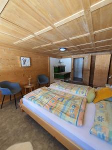 a bedroom with a large bed and a wooden ceiling at Burgbühler Guesthouse in Lenk