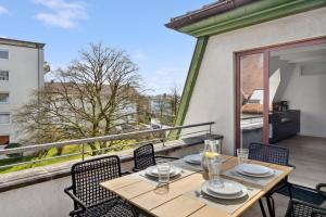 a table and chairs on a balcony with a view at Bodensee Loft Traumhafte Ferienwohnung bis zu 10 Personen in Tettnang