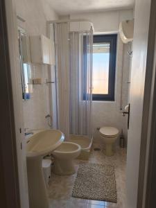 a bathroom with two toilets and a sink and a shower at Cozy Apartments in Lido di Ostia