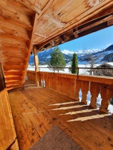 a wooden porch with a view of the mountains at Burgbühler Guesthouse in Lenk