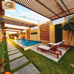 a swimming pool with a table and a bench at Marakos Pimentel in Pimentel