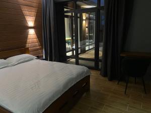a bedroom with a bed and a desk and a window at Маєток на Озерах in Ispas