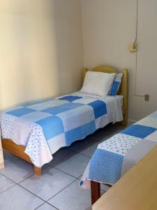 two beds in a room with blue and white sheets at Guilet Hotel l in São Borja