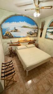 a room with three beds and a painting on the wall at B&B Sa Bèrtula in La Maddalena
