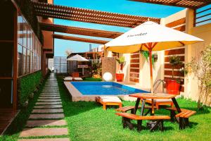 a patio with a table and an umbrella and a pool at Marakos Pimentel in Pimentel