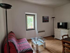 a living room with a couch and a glass table at Charmant t2 idéal Curiste 1min à pied de la cure thermale in Le Boulou