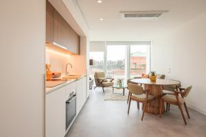 a kitchen and dining room with a table and chairs at Aveiro Central Appartment in Aveiro