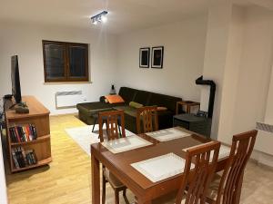 a living room with a table and a couch at Kupres Apartman555 in Kupres +22 photos