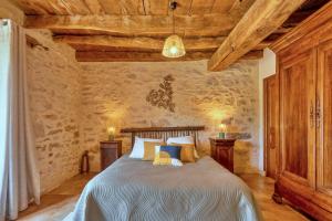 a bedroom with a bed in a room with wooden ceilings at Chambres et Jardin de Pierres in Espédaillac +55 photos