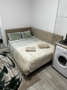 a bedroom with a bed and a washing machine at Rosu Residence 2 in Onești