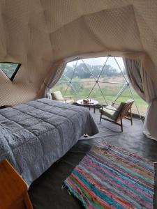 a bedroom with a bed and a large window at LA Viella Glamp Tala in Mar del Plata
